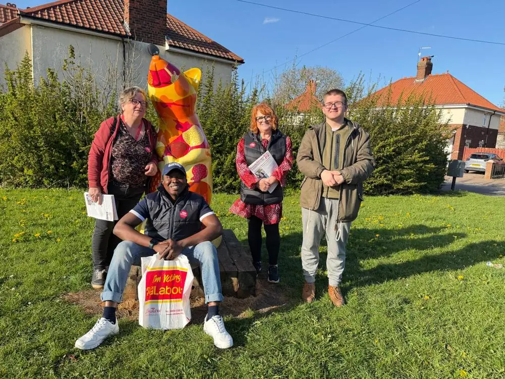 Ebenezer and campaigners around a painted bear sculpture on a green